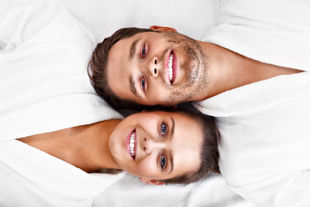 Man and woman laying down head to head looking upwards