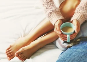 Woman sitting down with a cup of coffee