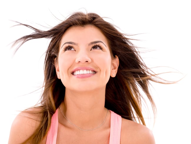 Happy woman looking up in the wind - isolated over white